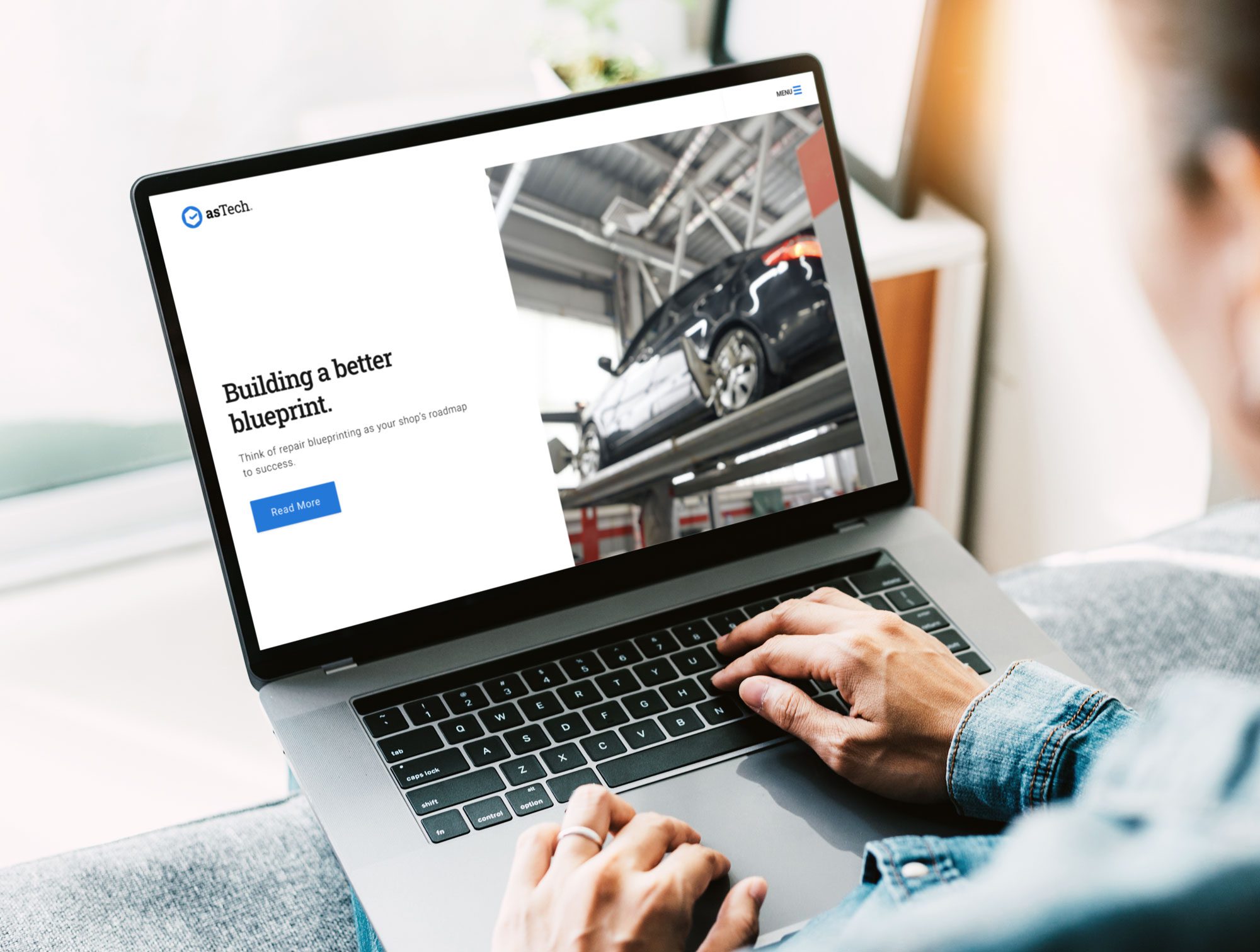 Hand poised over a laptop keyboard on the Astech website