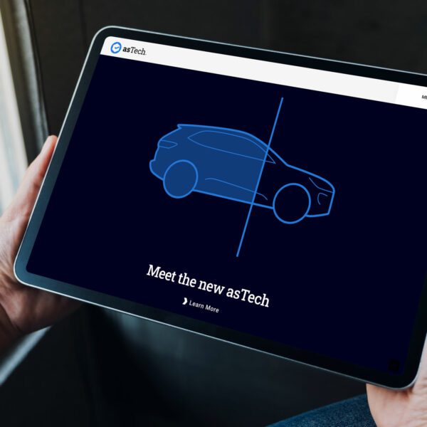 Hands holding a tablet showing an illustration of a vehicle being scanned